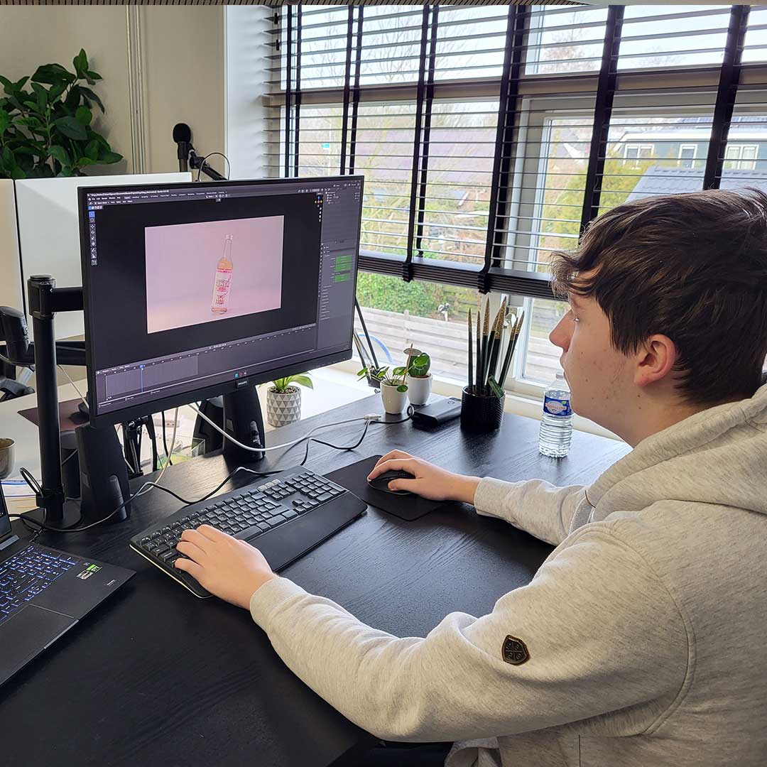 A colleague works on a 3D image of a bottle in Blender