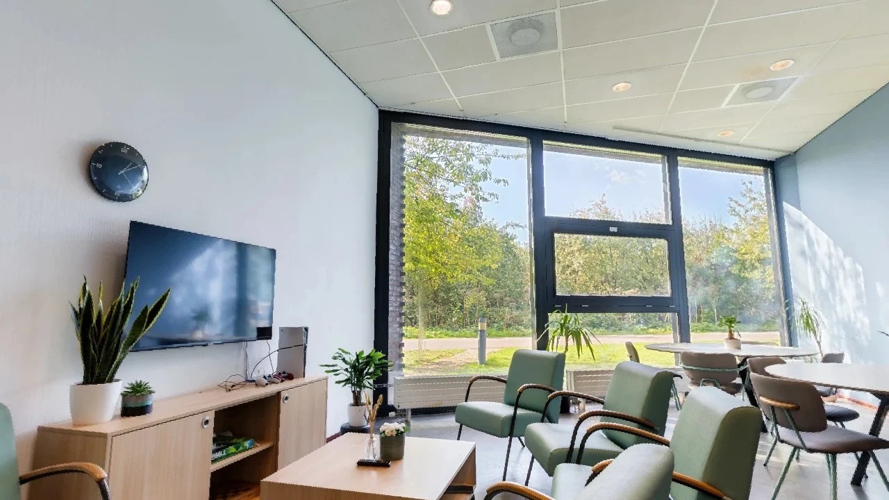 Shared living room at AFZ Rotterdam with a seating area, television and dining table