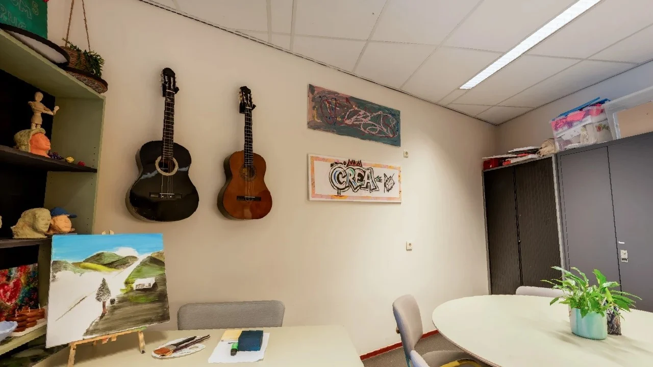 Activity room at FVK Rotterdam with worktables, paintings and materials