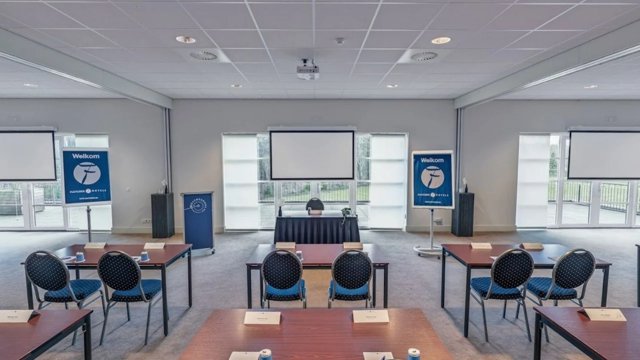 Vergaderzaal bij Fletcher met tafels, stoelen en projectiescherm