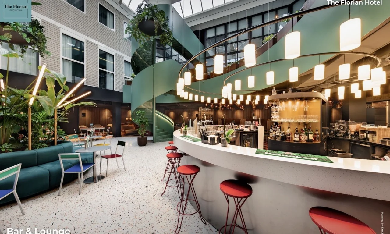 Bar and lounge at The Florian Hotel with a circular bar, green staircase and seating areas