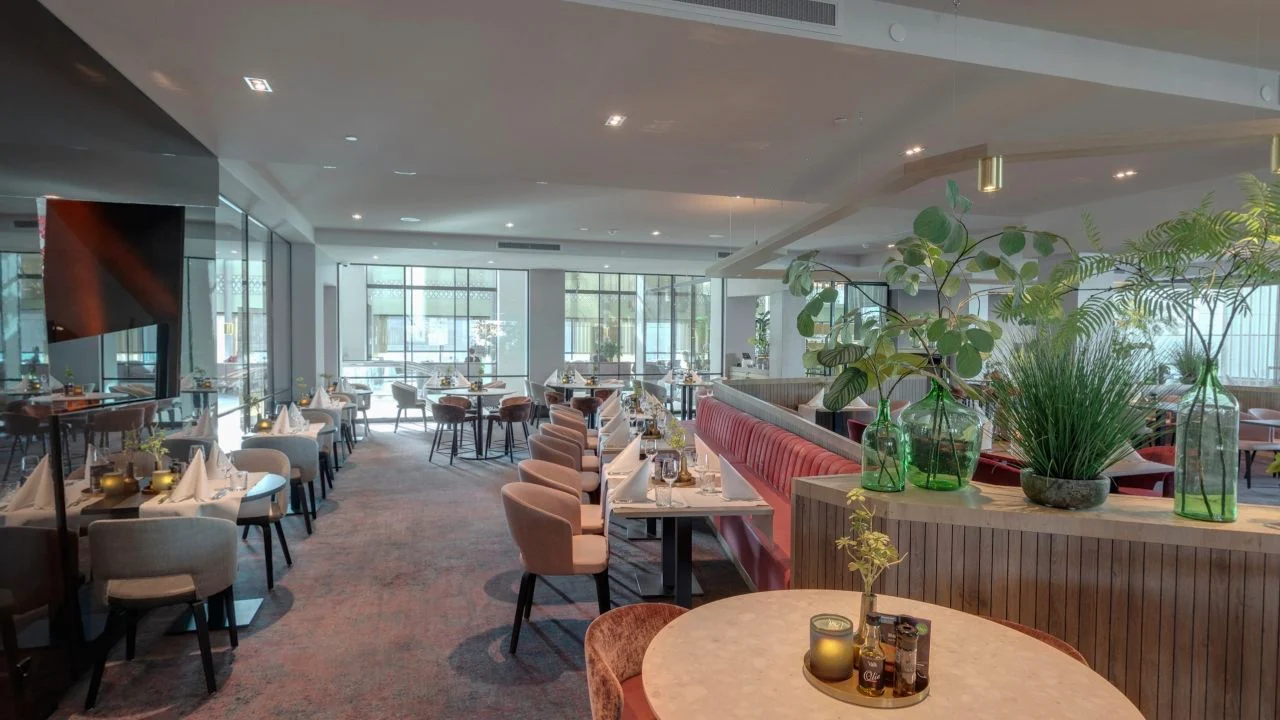 Restaurant van Van der Valk Hotel Haarlem met gedekte tafels, zitbanken en veel daglicht