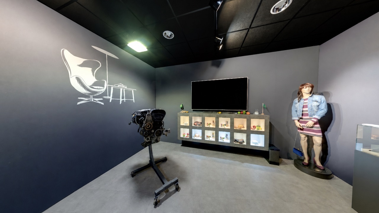 Techniekpresentatie met motoronderdeel, productvitrine en mannequin in het Inspiratiecentrum van Technische Unie