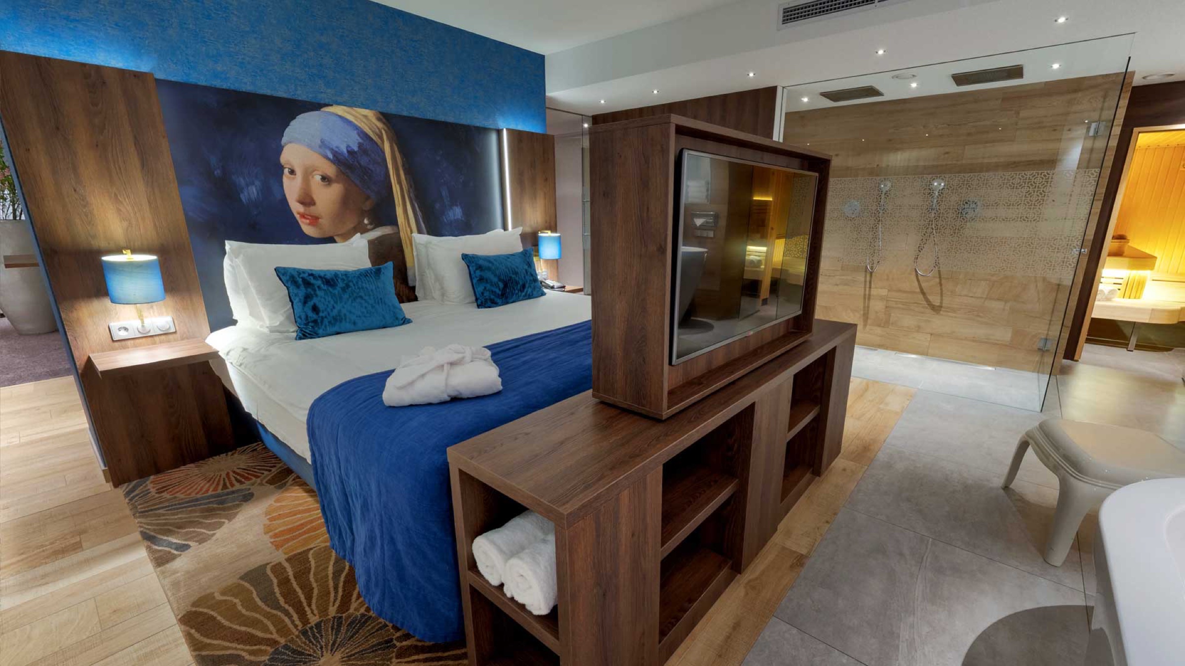 Luxe hotelkamer met Vermeerwand, glazen badkamer en sauna