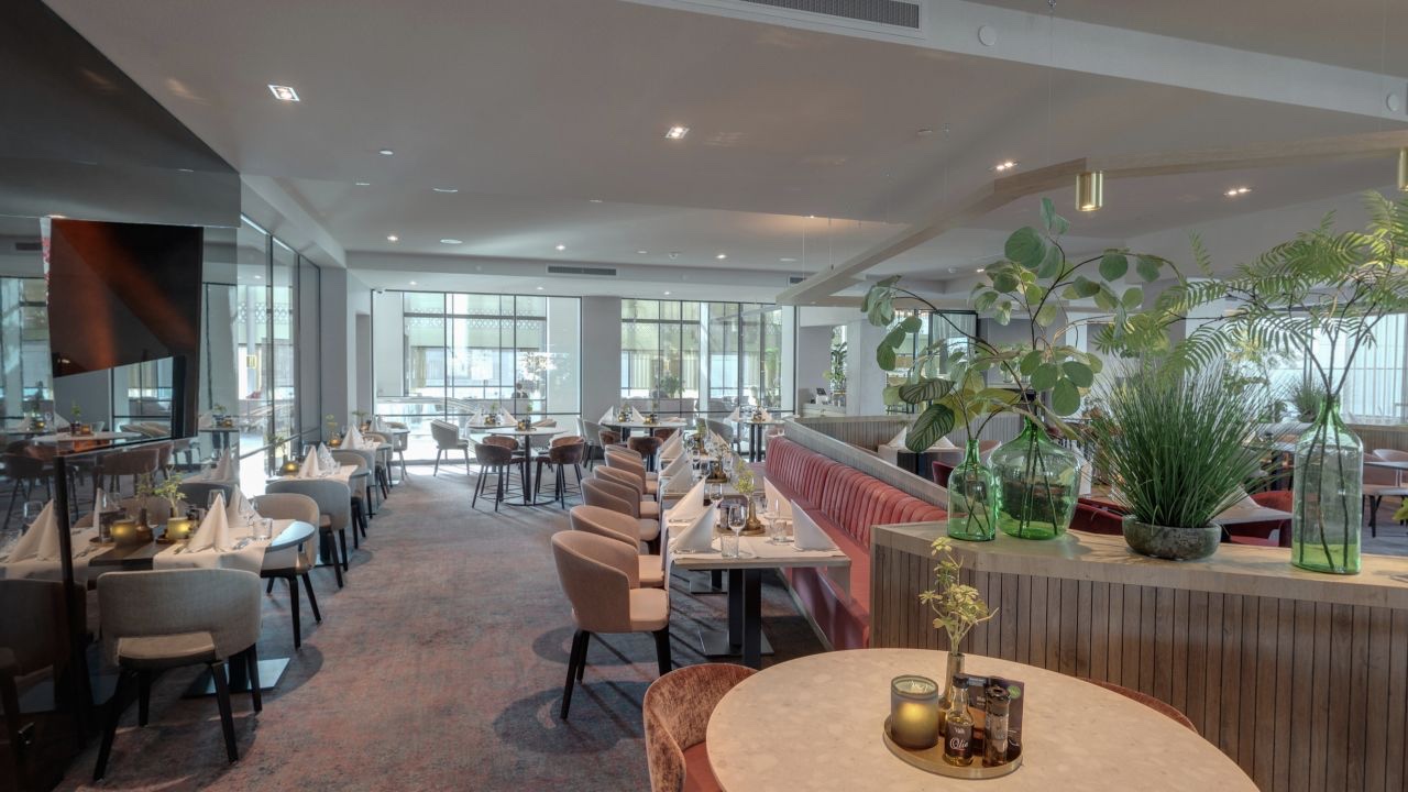 Restaurant van Van der Valk Hotel Haarlem met gedekte tafels, zitbanken en veel daglicht